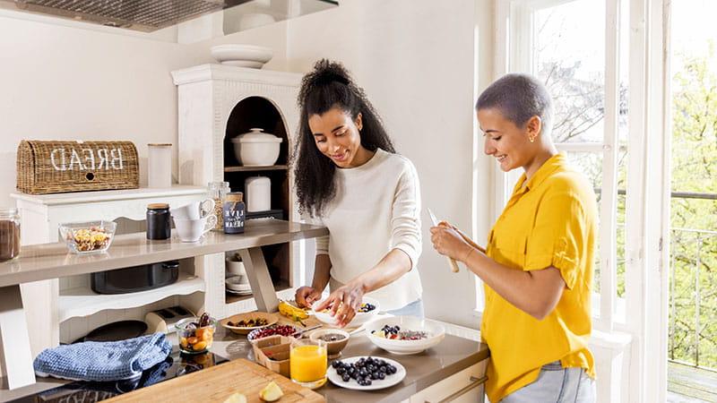 两个年轻的女人在厨房做健康的早餐.