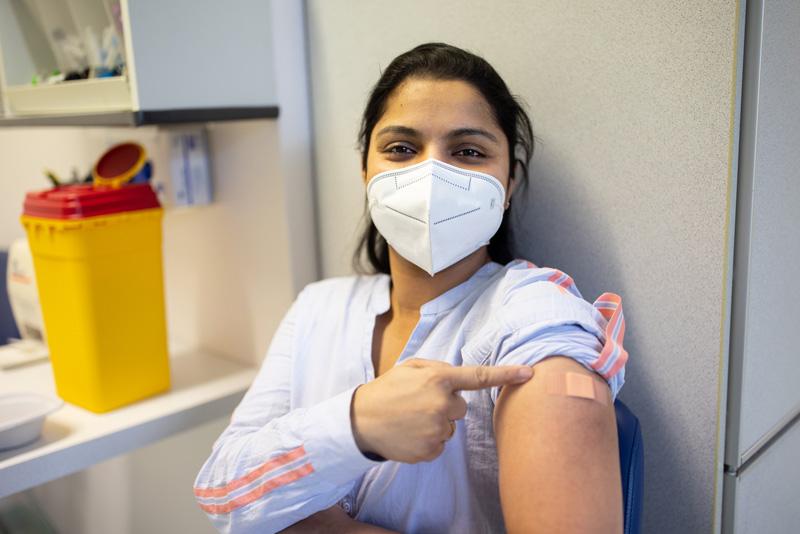 woman showing off where she received vaccine
